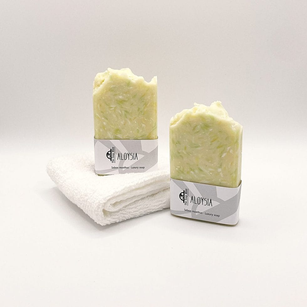 Two bars of white and green Aloysia handmade soap and a white facecloth