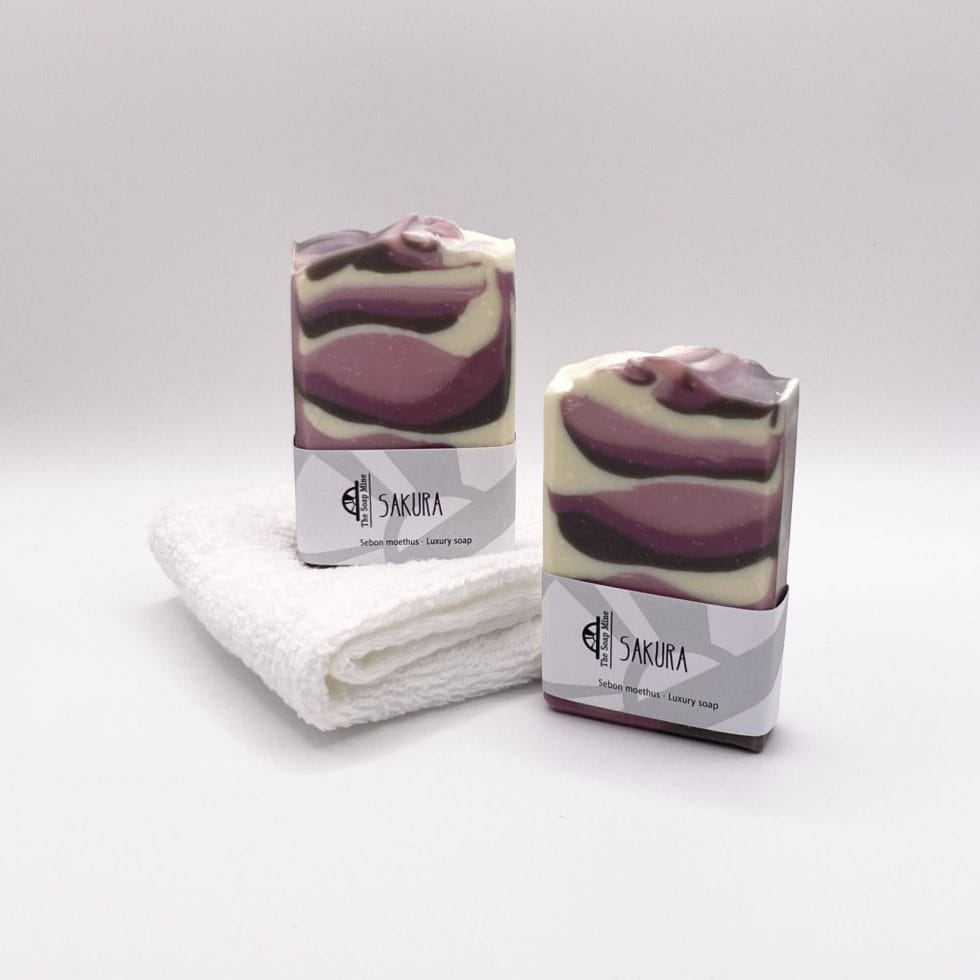 Two bars of pink and white Sakura handmade soap and a white facecloth