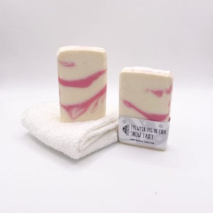 Two bars of pink and white handmade soap and a white facecloth