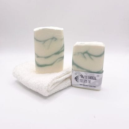 Two bars of white and green soap and a white facecloth