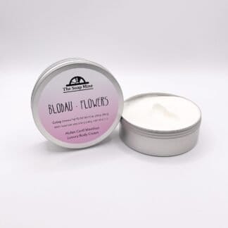 A tin of body cream with a pink and white label