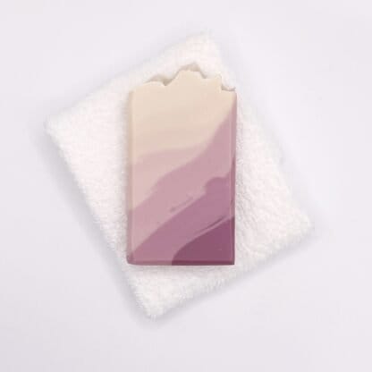 One bar of pink and white handmade soap and a white facecloth