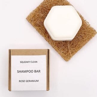 One bar of Rose Geranium Shampoo on a soap saver with the box at its side